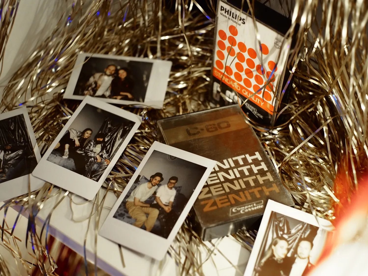Instant photo booth prints scattered among gold streamers