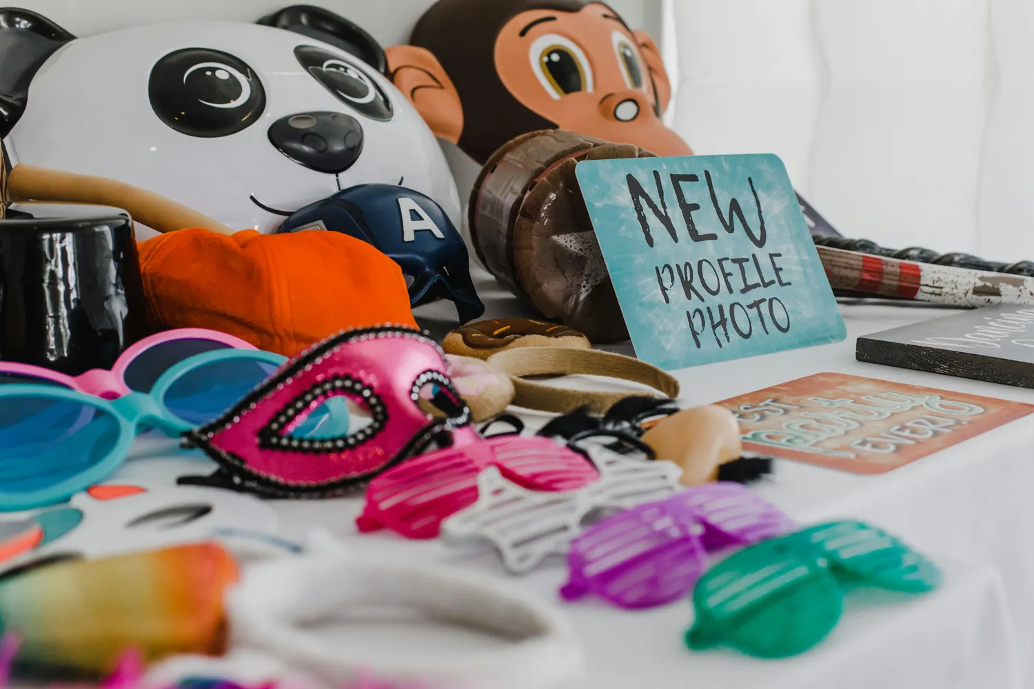 A table of colorful photo booth props — glasses, masks and signs